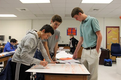Nick Medina, Bennett Webb, and Dylan Robicheaux, students at Gulfport High School, write down observations from the previous day's science lab. (Photo by Jackie Mader)