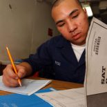 Chanthorn Peou of San Diego, Calif., takes the SAT aboard the USS Kitty Hawk (U.S. Navy photo by Jason T. Poplin)