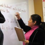 Ana, a 52 year old cafeteria cashier, completes an ESOL workbook exercise on the board at Harvard University’s Bridge Program. (Photo by Sarah Butrymowicz)
