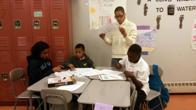 Students at Thurgood Marshall Academy work with one of their after-school helpers to figure out a science project. (Photo: Sarah Butrymowicz)