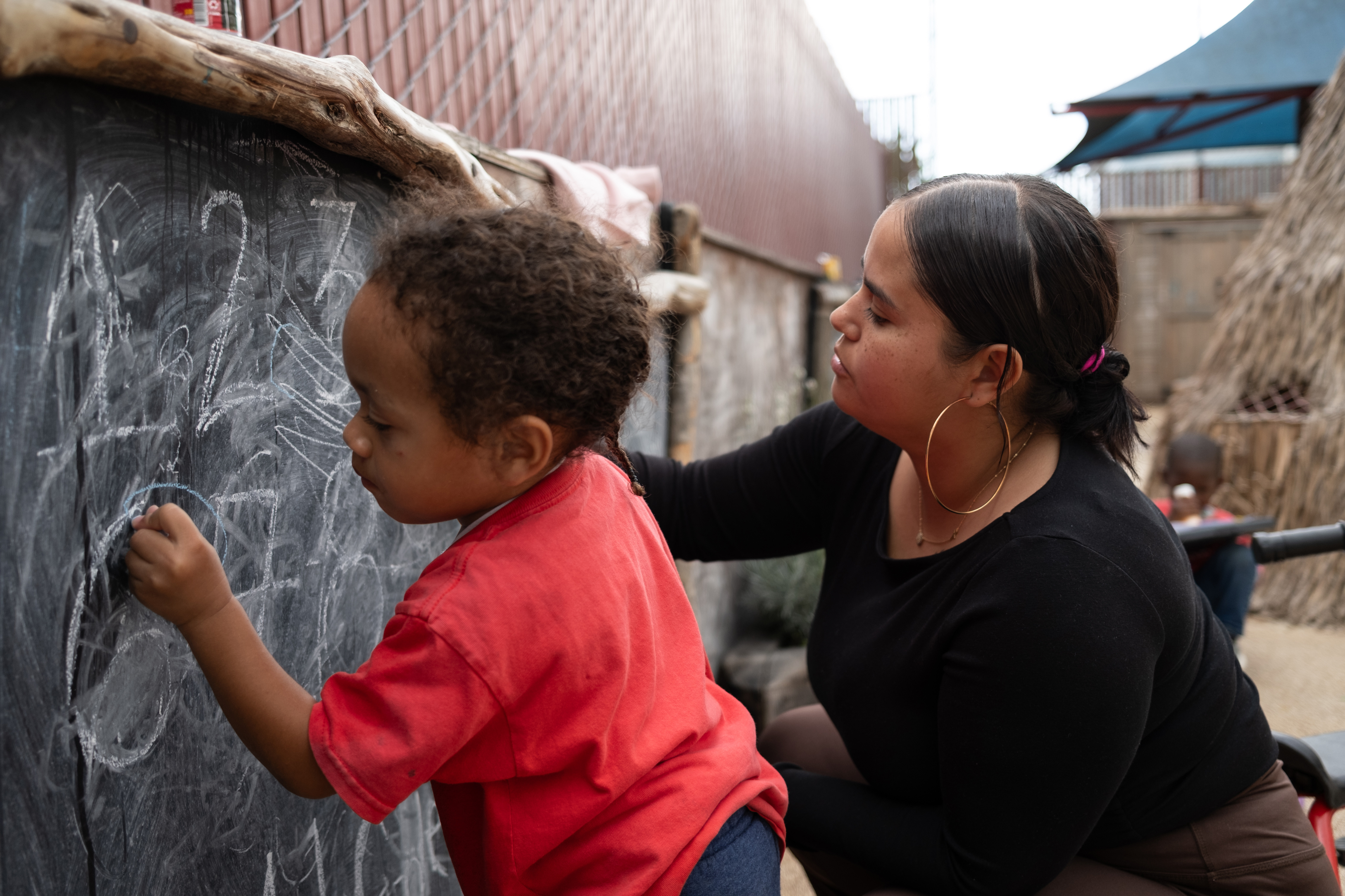 A teacher interacting with a young child in an early education setting